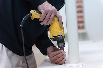 Image showing repairman working with drilling machine