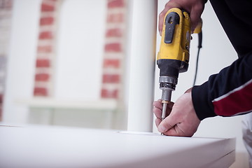 Image showing repairman working with drilling machine