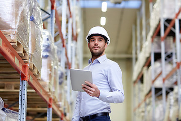 Image showing happy businessman with tablet pc at warehouse