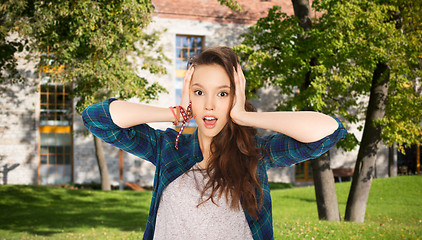 Image showing pretty teenage student girl holding to head