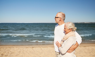 Image showing happy senior couple walking along summer beach