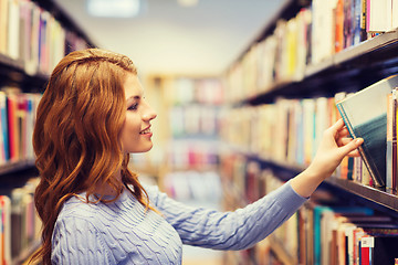 Image showing happy student girl or woman with book in library