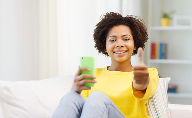 Image showing happy african woman with smartphone at home