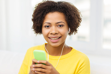 Image showing happy african woman with smartphone and earphones