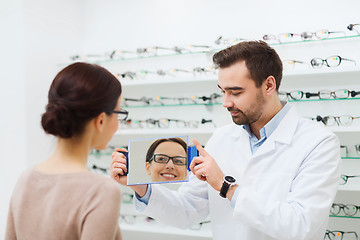 Image showing woman in glasses looking to mirror at optics store