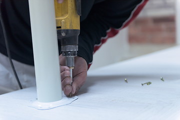 Image showing repairman working with drilling machine