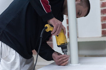 Image showing repairman working with drilling machine