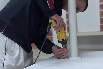 Image showing repairman working with drilling machine