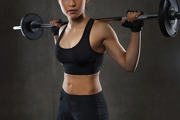 Image showing young woman flexing muscles with barbell in gym