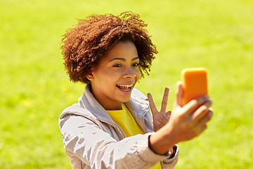 Image showing happy african woman taking selfie with smartphone