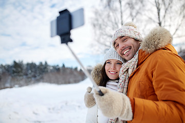 Image showing happy couple taking selfie by smartphone in winter