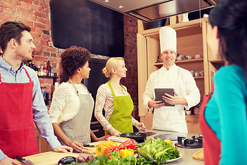 Image showing happy friends with tablet pc in kitchen