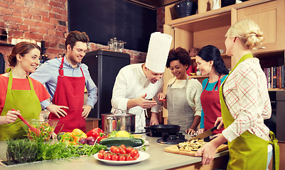 Image showing happy friends and chef cook cooking in kitchen