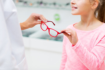 Image showing close up of girl taking glasses at optics store