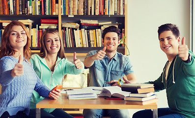 Image showing students with books showing thumbs up in library