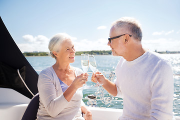 Image showing senior couple clinking glasses on boat or yacht