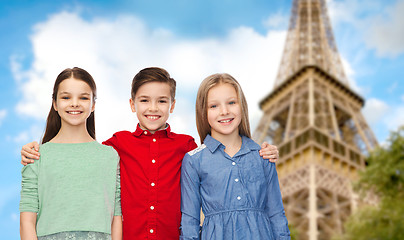 Image showing happy boy and girls hugging over eiffel tower