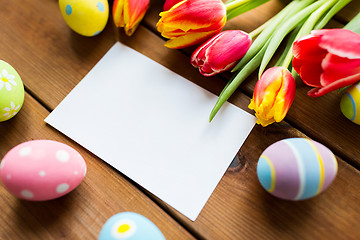 Image showing close up of easter eggs, flowers and white paper