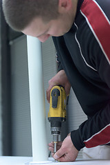 Image showing repairman working with drilling machine