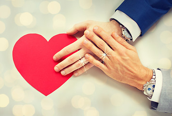 Image showing close up of male gay couple hands with red heart