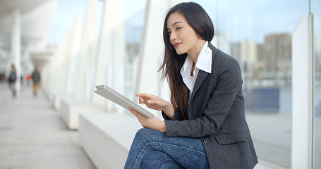 Image showing Stylish woman surfing the internet in town