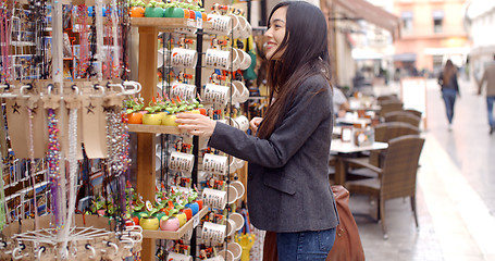 Image showing Smiling young woman checking out shop merchandise