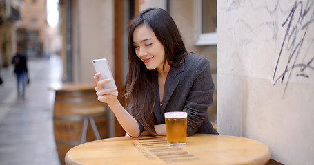 Image showing Smiling young woman relaxing with a beer