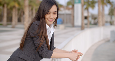 Image showing Relaxed thoughtful young woman leaning on railings