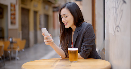 Image showing Smiling young woman relaxing with a beer