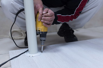 Image showing repairman working with drilling machine