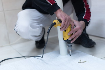 Image showing repairman working with drilling machine