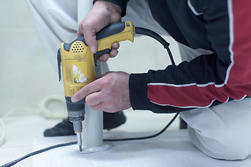 Image showing repairman working with drilling machine