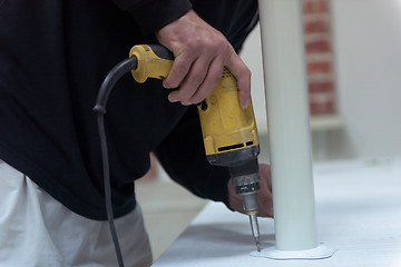 Image showing repairman working with drilling machine