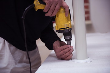 Image showing repairman working with drilling machine