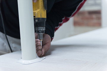 Image showing repairman working with drilling machine