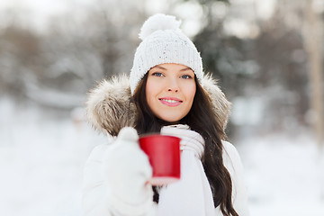 Image showing happy young woman with tea cup outdoors in winter