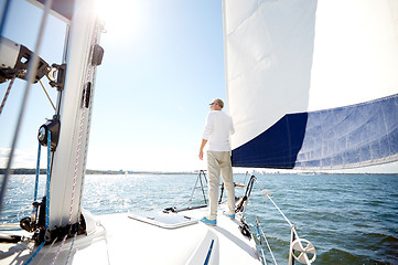 Image showing senior man on sail boat or yacht sailing in sea