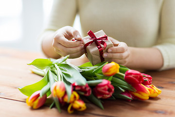 Image showing close up of woman with gift box and tulip flowers