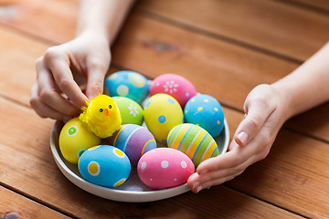 Image showing close up of woman hands with colored easter eggs