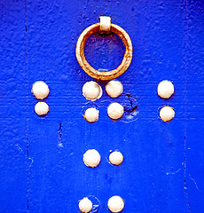 Image showing rusty metal     nail dirty stripped paint in the blue wood door 