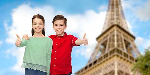 Image showing boy and girl showing thumbs up over eiffel tower