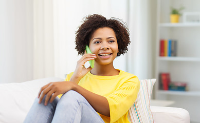 Image showing happy african woman with smartphone at home