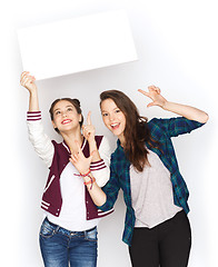 Image showing smiling teenage girls holding white blank board