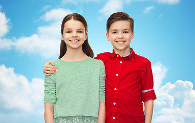 Image showing happy boy and girl hugging over blue sky