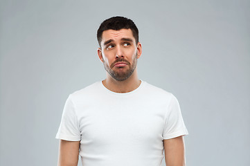 Image showing unhappy young man over gray background