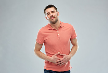 Image showing unhappy man suffering from stomach ache