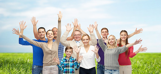 Image showing group of smiling people waving hands