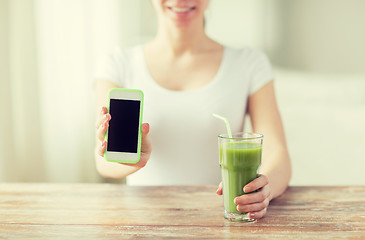 Image showing close up of woman with smartphone and green juice
