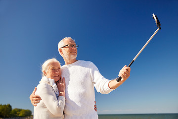 Image showing seniors with smartphone taking selfie on beach