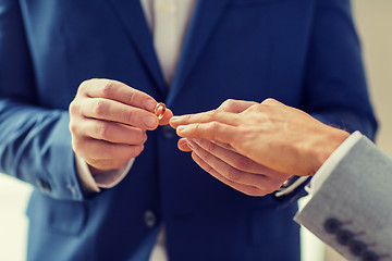 Image showing close up of male gay couple hands and wedding ring